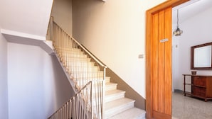 A staircase with a wooden handrail and white steps leading to a wooden door. - 4086 Maison Malù by Barbarhouse (Nardò)