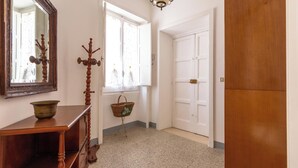 A hallway with a wooden dresser, a mirror, a candelabra, a basket, and a door. - 4086 Maison Malù by Barbarhouse (Nardò)