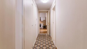 Un pasillo estrecho con piso estampado que conduce a una zona de cocina.