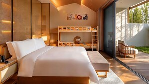 Ein modernes Schlafzimmer mit einem großen Bett, einem Schlafplatz für Kinder, einer hölzernen Bank und einem Stuhl.