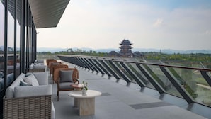 A rooftop terrace with seating, a view of traditional architecture, and a railing. - Chengdu Expo Waterfall Hotel - Mgallery Collection (Chengdu)