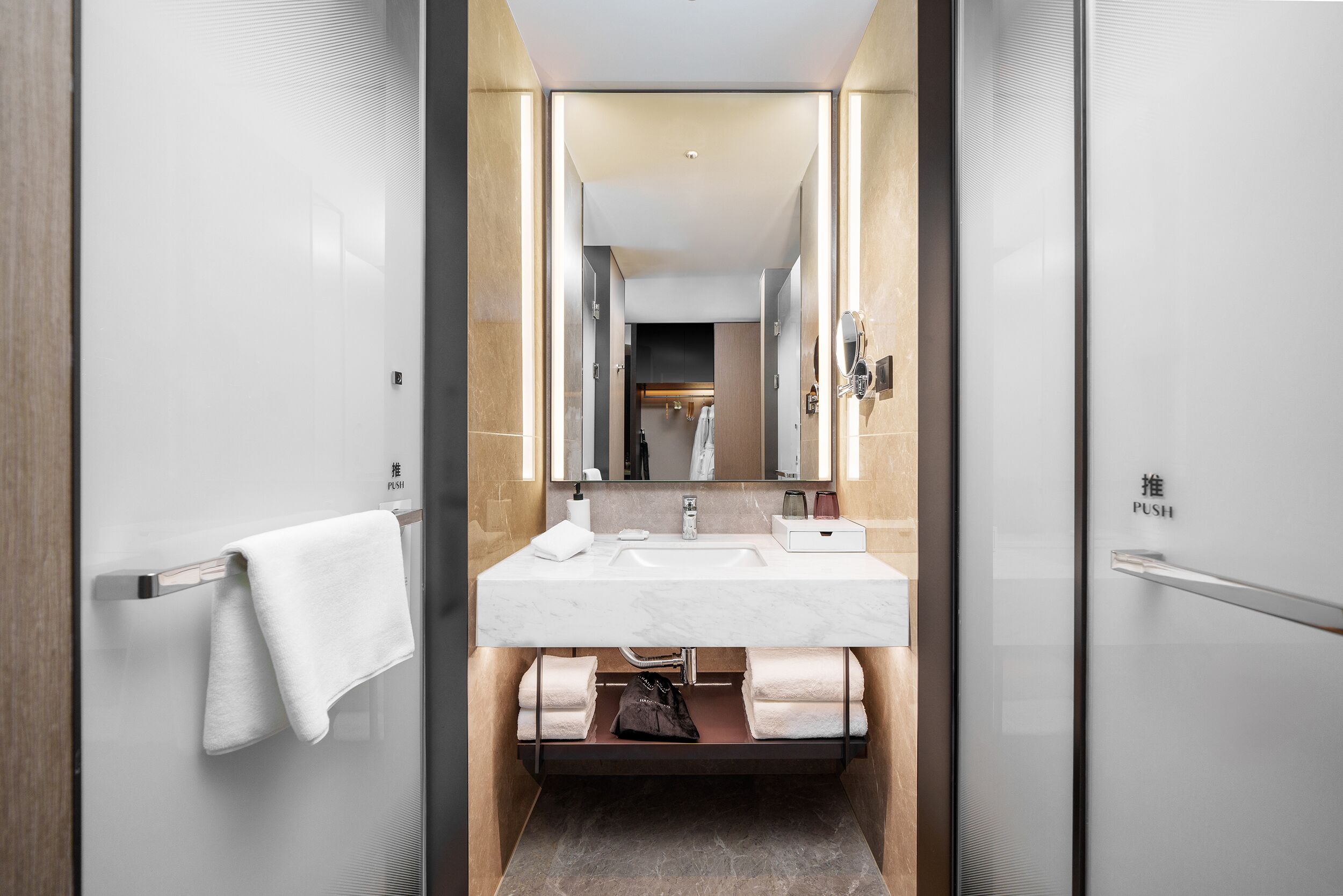 A modern bathroom with a white sink, mirror, and towel rack.