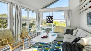 A bright, sunlit room with a large window, a white ceiling, and a colorful hexagonal floor pattern.