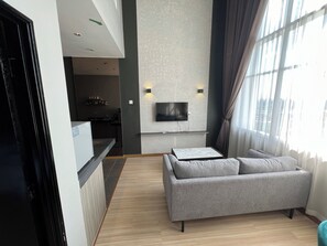 Familienapartment, Stadtblick | Wohnbereich | Flachbildfernseher