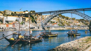 A harbor with boats, a bridge, and buildings in the background. - Cozy Studio Central Porto: A/C and Kitchen (Porto)
