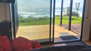 A room with a large sliding glass door leading to a wooden deck overlooking the ocean. - Hole in the rock studio
Welcome to the hole in the rock Studio,  (Cape Foulwind)