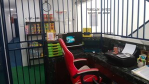A small office area with a desk, chair, computer, and various office supplies. There is a clock on the wall and a sign that reads "VAIGAN HOTEL." - Hotel O Vaigan Hotel (Bintulu)