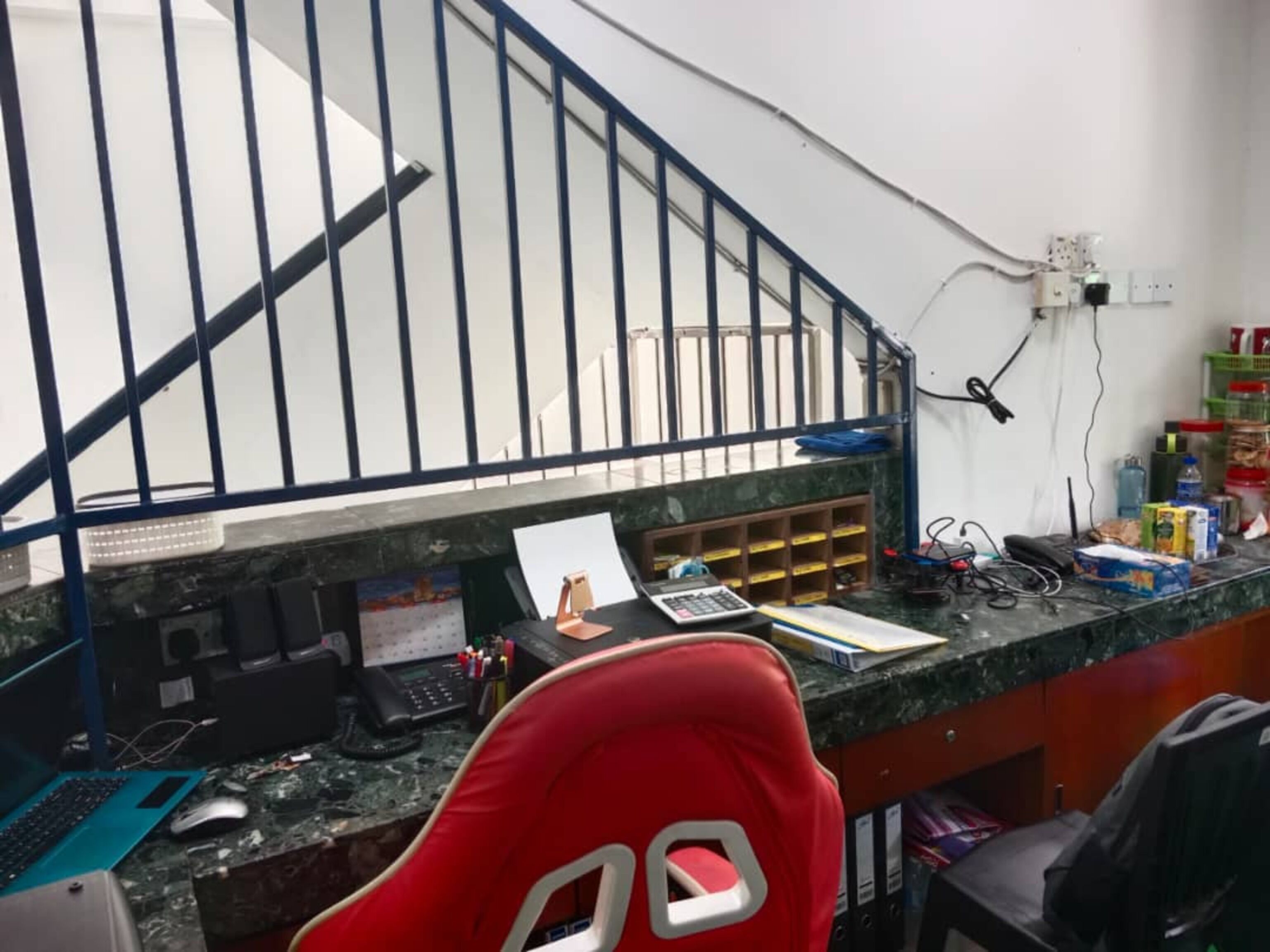 A workspace with a desk, computer, and various office supplies.