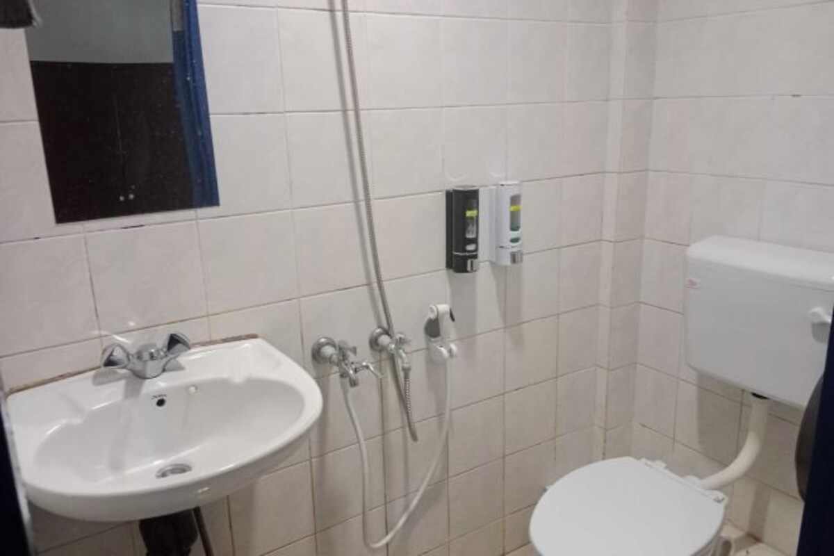 A bathroom with a white sink, a toilet, and a shower unit.