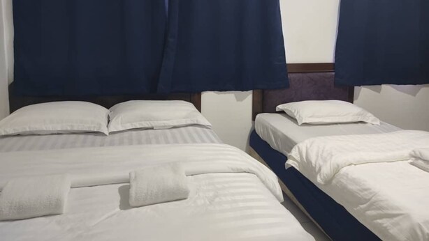 Two single beds with white linens and blue curtains. - Hotel O Vaigan Hotel (Bintulu)