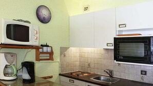 A kitchen with white cabinets, a microwave, a toaster, a coffee maker, and a clock on the wall. - Studio 4 pers. direct access slopes, center and south-facing balcony (Les Orres)