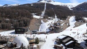 A ski resort with a large dome-shaped building, a ski lift, and a mountain backdrop. - Studio 4 pers. direct access slopes, center and south-facing balcony (Les Orres)