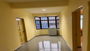 A hallway with a tiled floor, a window with black bars, and a door on the left. - Hotel O RAHMAH SOJOURN CENTRE (Johor Bahru)