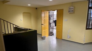 A hallway with a staircase, a door leading to another room, and a utility box on the wall. - Hotel O RAHMAH SOJOURN CENTRE (Johor Bahru)