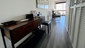 A modern kitchen with a wooden countertop, a black chair, and a dining table.