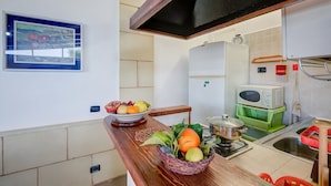 A kitchen with a wooden countertop, a microwave, a sink, and a potted plant. - Villa Oasi al Mare Near the sea With Pool (Melendugno)