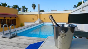 A poolside area with a metal bucket containing a bottle, a pool, and a wooden deck. - Villa Oasi al Mare Near the sea With Pool (Melendugno)