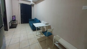 Un espace de vie compact comprenant un canapé, une petite table et une chaise.
