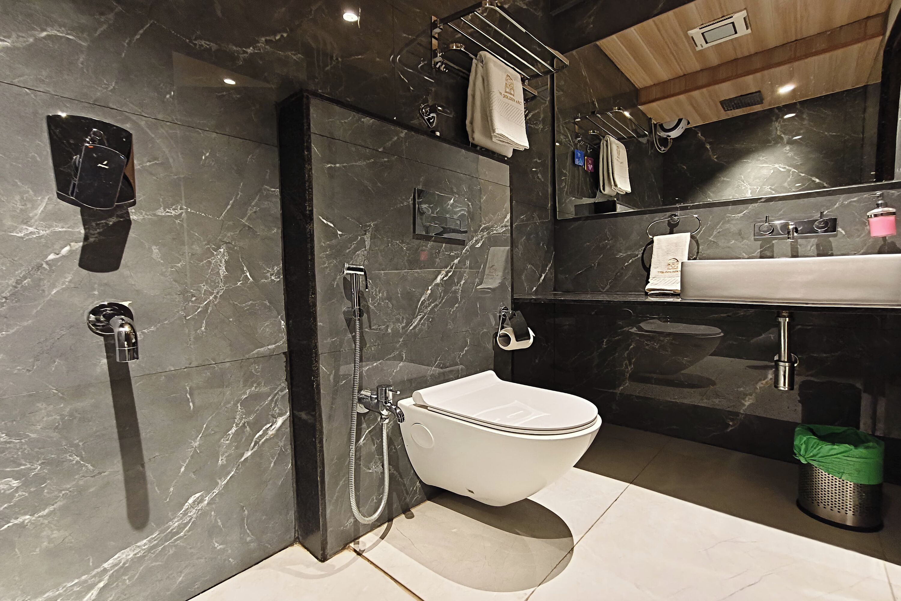A modern bathroom with a toilet, shower, and sink.