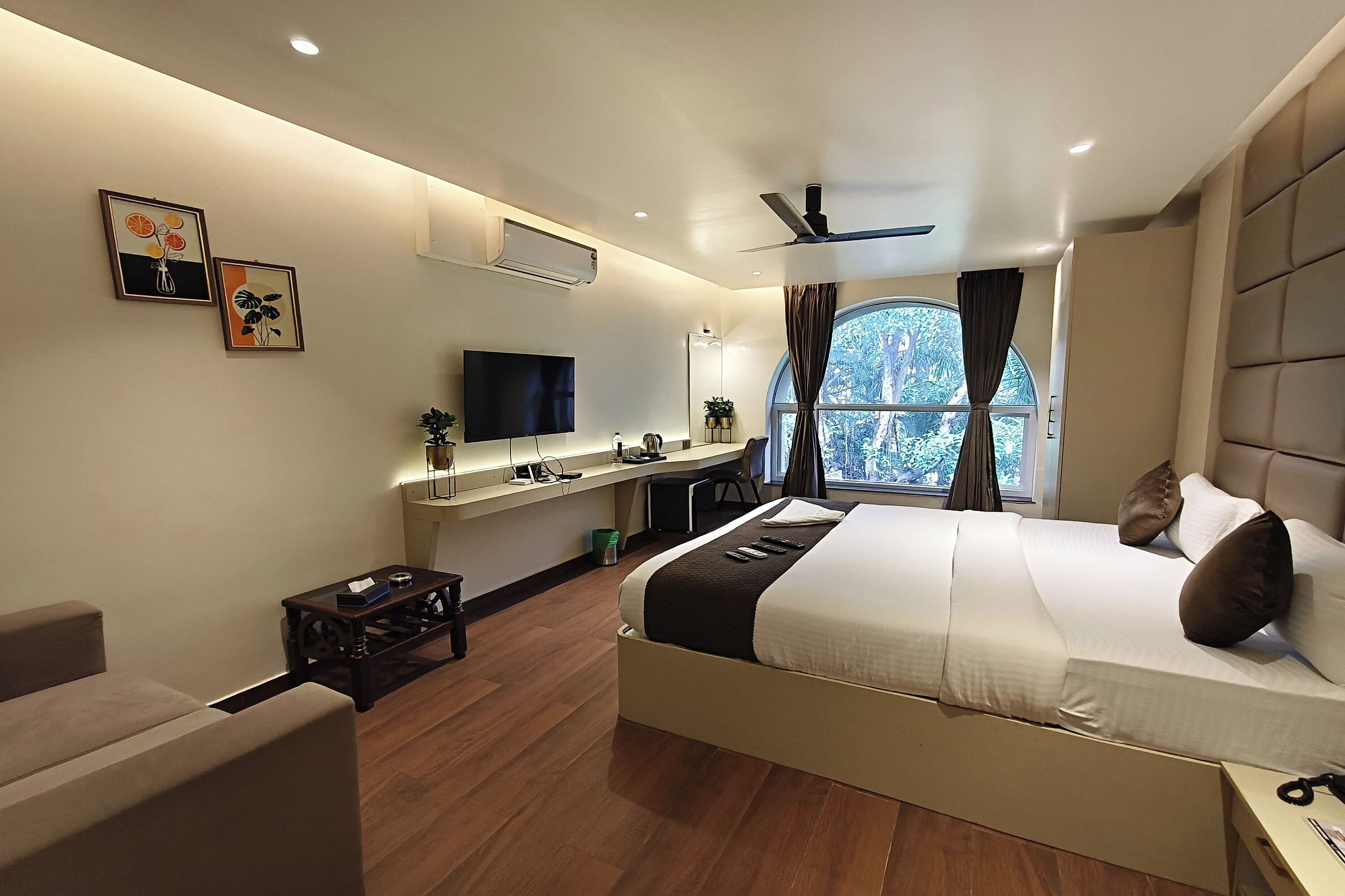 Una habitación de hotel moderna con cama, escritorio y televisión.