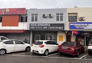 A parking lot with several cars parked in front of a building with a sign for 'Kedai Serbaneka Kim Toys and Stationary'. - Hotel O Tampoi Sojourn (Johor Bahru)