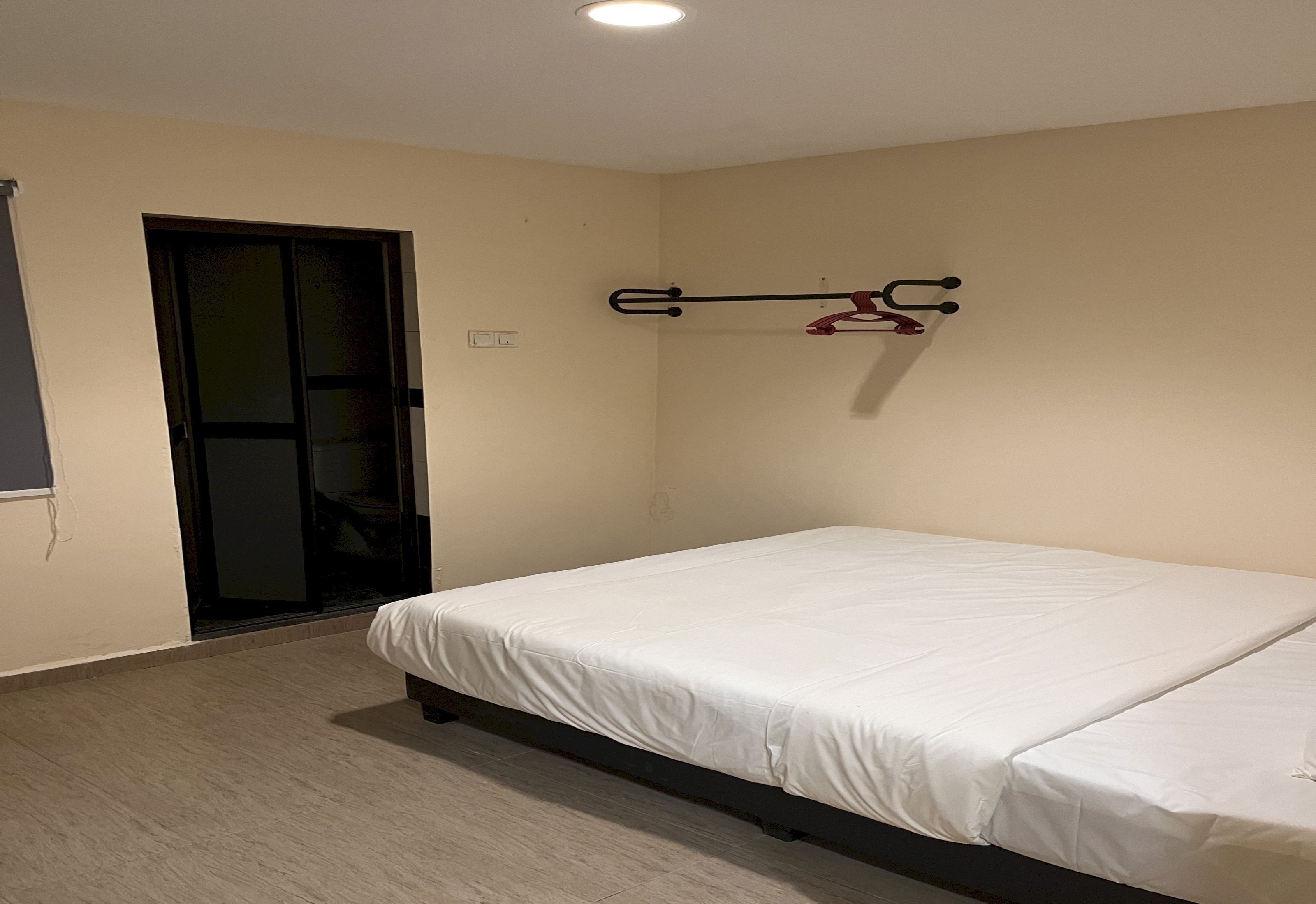 Una camera da letto con un letto, una porta e un gancio a muro.