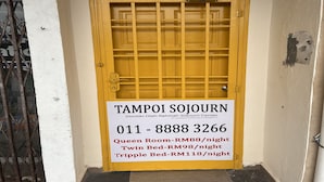 A yellow door with a sign indicating room rates for a sojourn center.