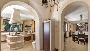 A spacious kitchen with a central island, arched ceilings, and a dining area with a table and chairs. - 4015 Masseria Scilla by Barbarhouse (Carovigno)