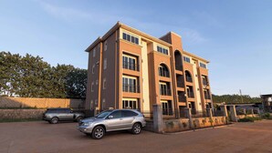 A multi-story residential building with a brick facade, multiple balconies, and a gated entrance. - Hotel 256 Kampala (Kampala)