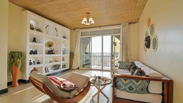 A living room with a hammock, a sofa, a bookshelf, and a large window. - Hotel 256 Kampala (Kampala)