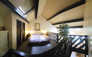 A room with a bed, a nightstand, a mirror, and a potted plant. - Langford Apartments and Rooms (Bristol)
