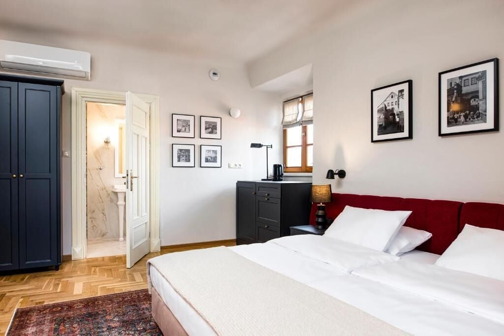 Un dormitorio con cama, armario, escritorio y ventana.