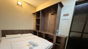 A hotel room with a bed, a wooden wardrobe, and a no-smoking sign. - Hotel O Ezi Inn (Kuala Kangsar)