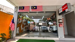 A hotel entrance with Malaysian and American flags, a green carpet, and a sign for 'COOP hotel'. - Hotel O Ezi Inn (Kuala Kangsar)