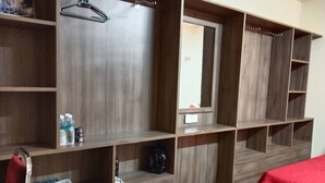A hotel room with a wooden wardrobe, a mirror, and a red bedspread. - Hotel O Ezi Inn (Kuala Kangsar)