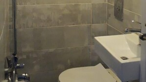 A small, compact bathroom with a toilet, sink, and shower. - Loft in Dbayeh,including Generator, Prime Location (Dbayeh)