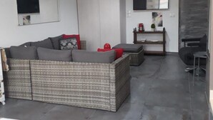 A modern living room with a sofa, a coffee table, and a TV mounted on the wall. - Loft in Dbayeh,including Generator, Prime Location (Dbayeh)