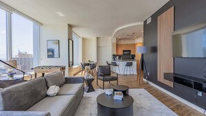 A modern living room with a sofa, coffee table, and a view of the city.