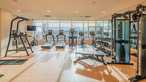 A gym with treadmills, elliptical machines, weight machines, and free weights.