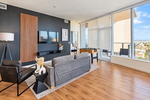 Una sala moderna con un sofá gris, una mesa de centro y una mesa de futbolín.