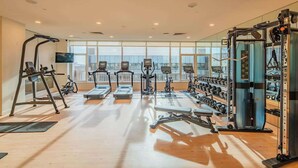 A gym with treadmills, elliptical machines, and weightlifting equipment.