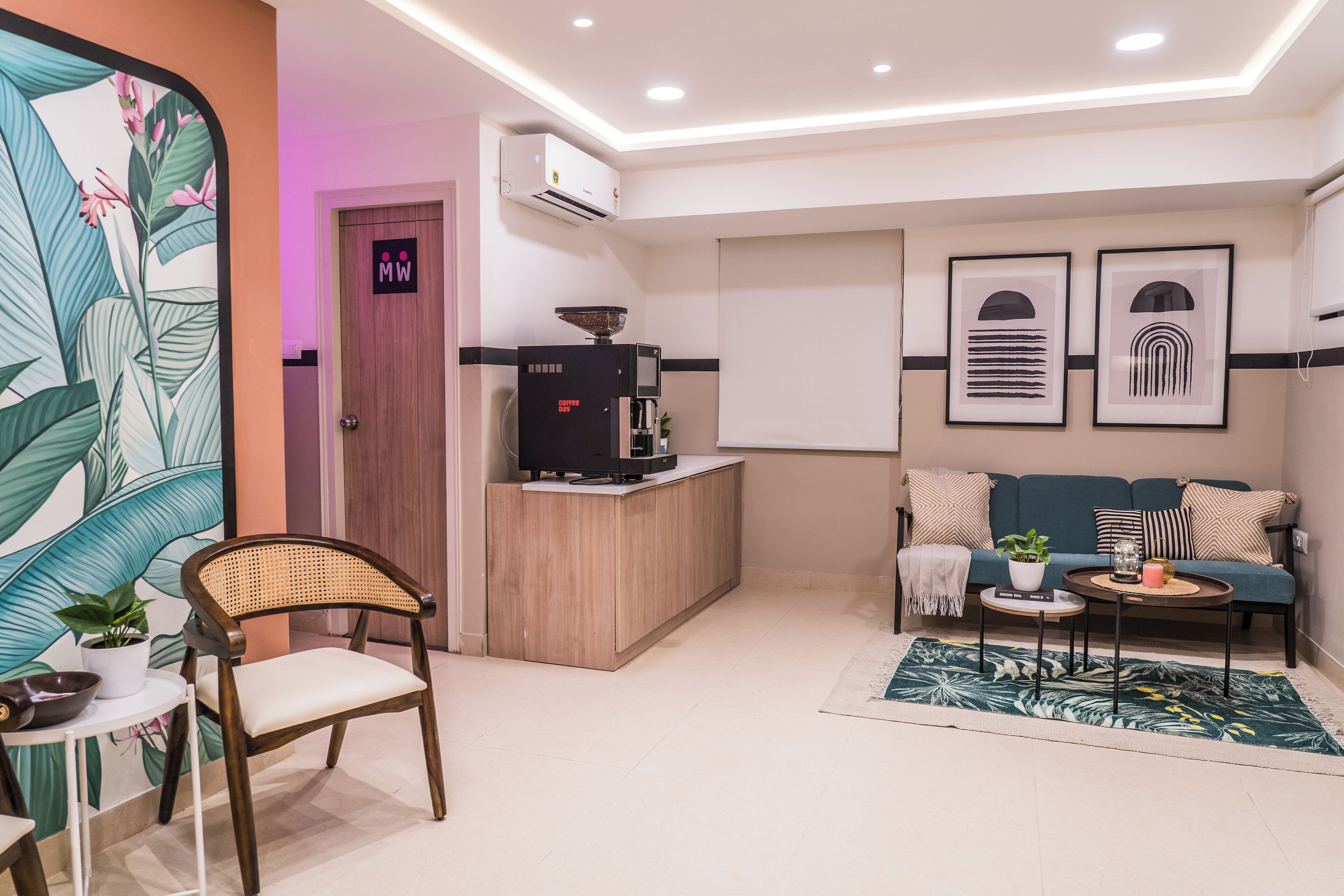 A modern living area with a sofa, a coffee machine, a dining table, and a chair.