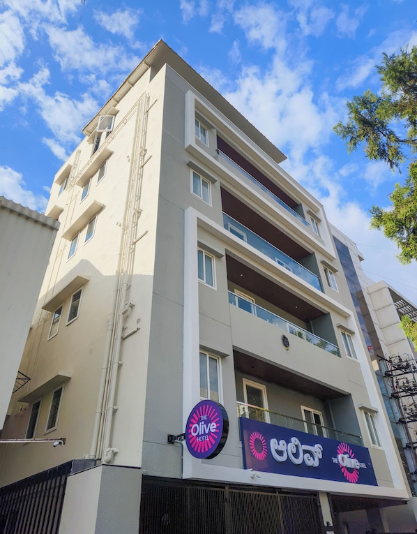 A multi-story hotel with balconies and a sign for "The Olive Hotel". - Olive Hotel Millers Road by Embassy Group (Bengaluru)