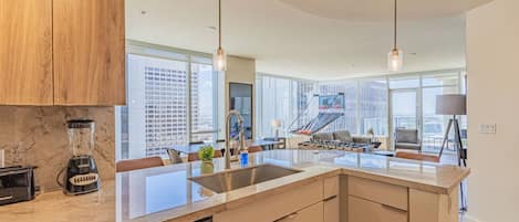 A modern kitchen with a dishwasher, a blender, and a large island.