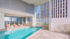 An indoor swimming pool with lounge chairs and large windows. - Stadium District Apt Pool,Gym,Balcony,Parking,WD (Phoenix)