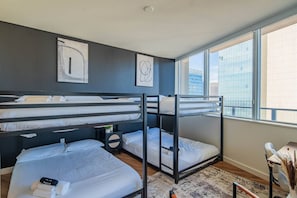 A modern hotel room with bunk beds, a large window with a city view, and a minimalist decor. - Stadium District Apt Pool,Gym,Balcony,Parking,WD (Phoenix)