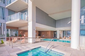 A hotel pool area with a small pool, lounge chairs, and a seating area. - Modern ASU Retreat | Pool | Gym | Balcony | W/D (Phoenix)