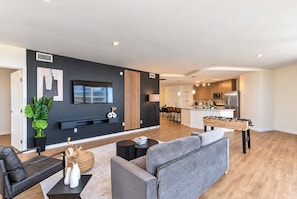 A modern apartment with a living area, kitchen, and dining space.