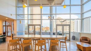 Una habitación amplia con ventanas grandes, una mesa redonda con sillas y vistas a la ciudad.
