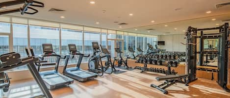 A gym with treadmills, elliptical machines, and weightlifting equipment.